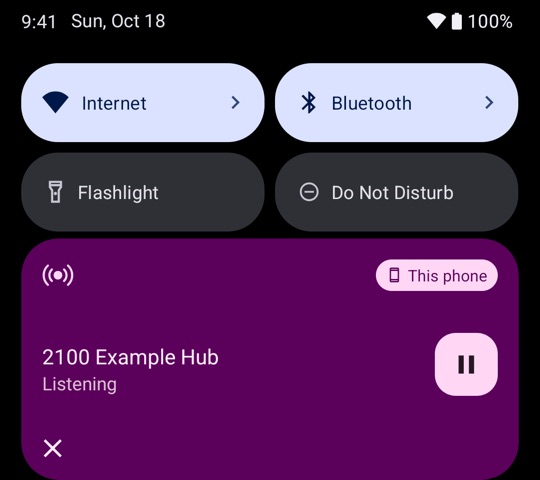The media card in the Android quick settings. It shows 2100 Example Hub, Listening, with a pause button and This phone.